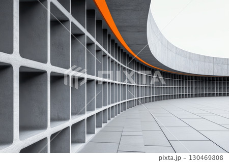 A contemporary architectural feature displays a smooth, curved concrete wall designed with textured square blocks 130469808