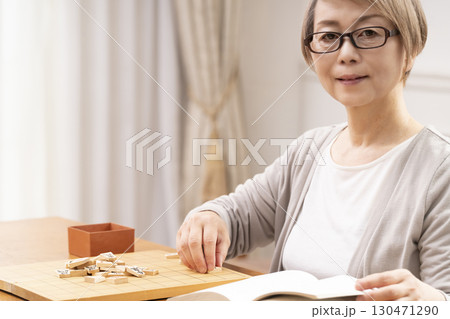 1人で趣味の将棋の練習をするシニア女性 130471290