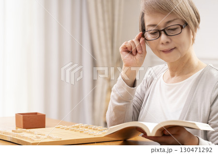 1人で趣味の将棋の練習をするシニア女性 130471292