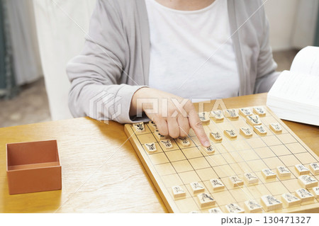 1人で趣味の将棋の練習をするシニア女性の手元 1人で趣味の将棋の練習をするシニア女性の手元 130471327