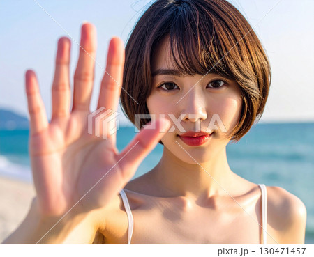 夕暮れ時の砂浜を満喫する若い女性/Young woman enjoying the sandy be 130471457