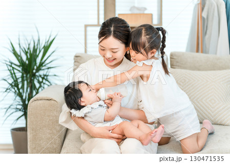 ソファーで赤ちゃんを抱っこする母親,ママ（育児,専業主婦） 130471535