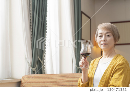 リビングでワインを飲んでくつろぐシニア女性 リビングでワインを飲んでくつろぐシニア女性 130471581