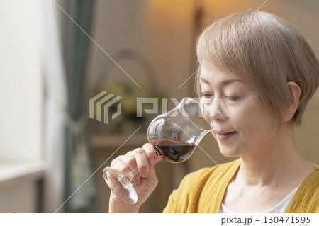 リビングでワインを飲んでくつろぐシニア女性 リビングでワインを飲んでくつろぐシニア女性 130471595