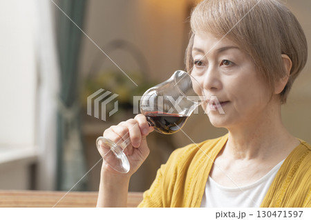 リビングでワインを飲んでくつろぐシニア女性 130471597