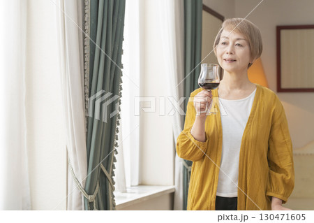 リビングでワインを飲んでくつろぐシニア女性 130471605