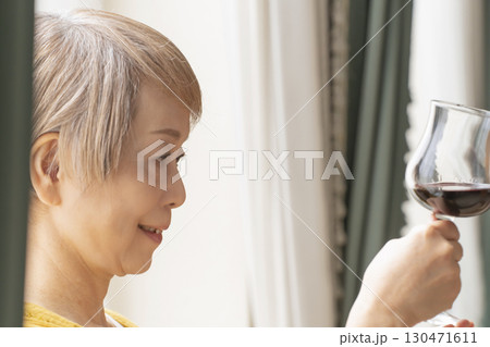 リビングでワインを飲んでくつろぐシニア女性 リビングでワインを飲んでくつろぐシニア女性 130471611
