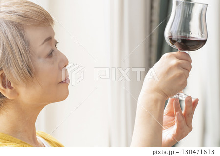 リビングでワインを飲んでくつろぐシニア女性 130471613