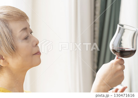 リビングでワインを飲んでくつろぐシニア女性 130471616