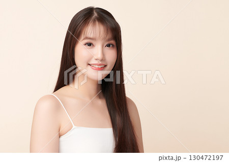 A beautiful young Asian woman with clean, fresh skin against a beige background. Skincare, facial treatment, cosmetology, beauty, and spa. An elegant portrait of an Asian woman. A beautiful young Asian woman with clean, fresh skin against a beige background. Skincare, facial treatment, cosmetology, beauty, and spa. An elegant portrait of an Asian woman. 130472197