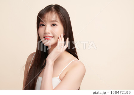 A beautiful young Asian woman with clean, fresh skin against a beige background. Skincare, facial treatment, cosmetology, beauty, and spa. An elegant portrait of an Asian woman. A beautiful young Asian woman with clean, fresh skin against a beige background. Skincare, facial treatment, cosmetology, beauty, and spa. An elegant portrait of an Asian woman. 130472199