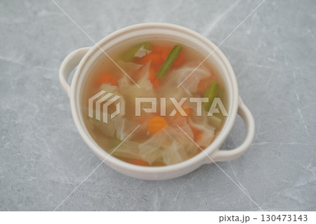 Vegetable Soup in White Bowl on a Gray Surface Vegetable Soup in White Bowl on a Gray Surface 130473143
