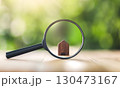 Wooden houses and magnifying glass. Property valuation. Home appraisal. Choice of location for the construction. 130473167