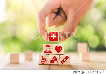 Hand arranged wooden blocks with icons of medical health. health insurance for your health concept. Healthcare medical business. 130473170