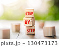 The word step by step on wooden cubes. Achievement or progress in business career. 130473173