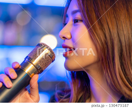 カラオケを楽しむ若い女性/ Young woman enjoying karaoke 130473187