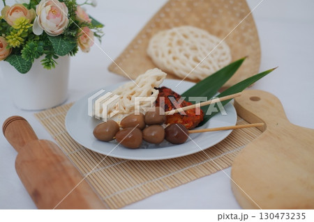 Indonesian Street Food Sate, Eggs, and Crackers on a White Plate 130473235
