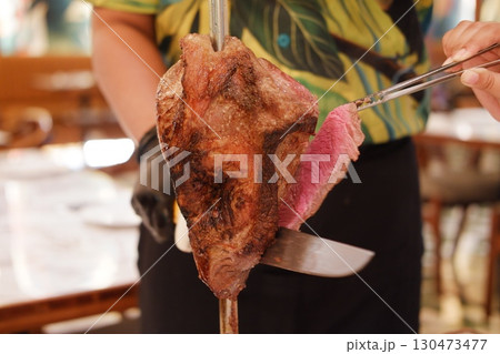 Brazilian Churrasco Slicing Delicious Grilled Meat Off the Skewer Brazilian Churrasco Slicing Delicious Grilled Meat Off the Skewer 130473477