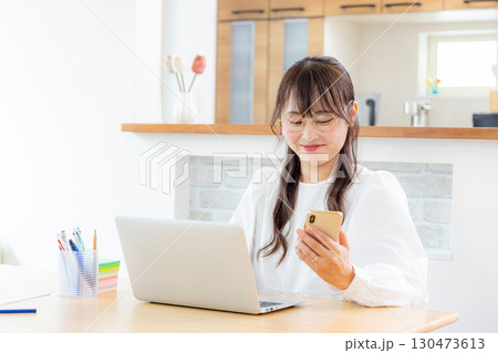 スマホを見るテレワークの女性 スマホを見るテレワークの女性 130473613