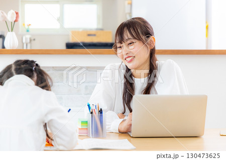 リビングで勉強する女の子と母親 130473625