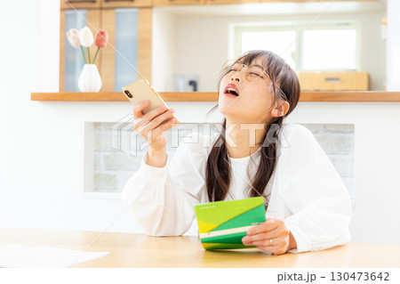 預金通帳を見て悩む女性 130473642