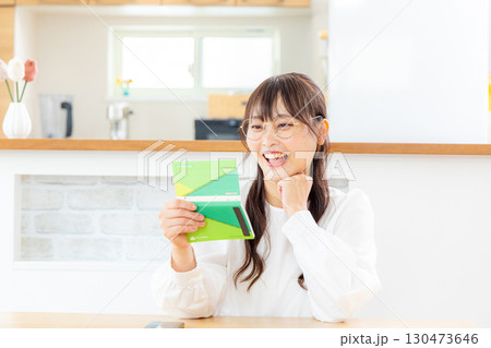 笑顔で通帳を確認する女性 130473646