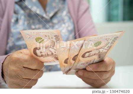 Retired elderly woman counting coins money and worry about monthly expenses and treatment fee payment. Retired elderly woman counting coins money and worry about monthly expenses and treatment fee payment. 130474020