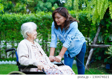 Caregiver help Asian elderly woman disability patient sitting on wheelchair in park, medical. 130474021