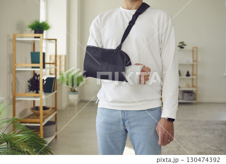 Man Standing with Broken Arm in Cast Man Standing with Broken Arm in Cast 130474392