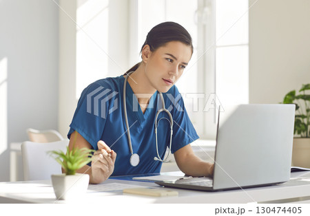 Dedicated Doctor Using Laptops in Hospital Office Dedicated Doctor Using Laptops in Hospital Office 130474405