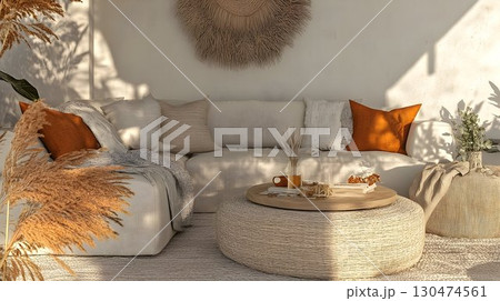 Beige sofa and round ottoman in a relaxing indoor living room setting 130474561