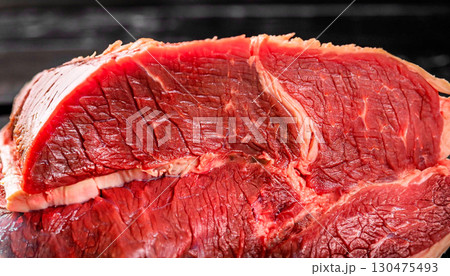 macro photo of boiled red beef meat on a black wooden surface macro photo of boiled red beef meat on a black wooden surface 130475493