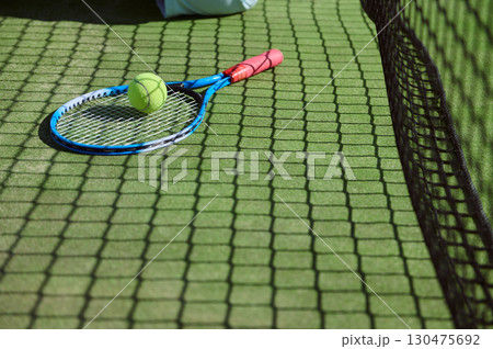 Tennis Racket and Ball on Grass Court with Net Shadow in View 130475692