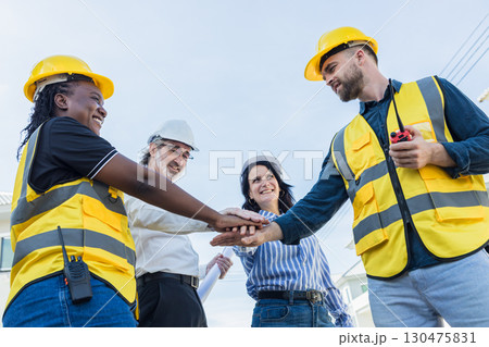 Diverse Construction engineer profession workers people join hands, Group of multiethnic company. 130475831