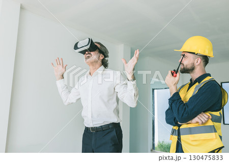 Construction manager happy using VR visual presentation technology device present by builder at site 130475833