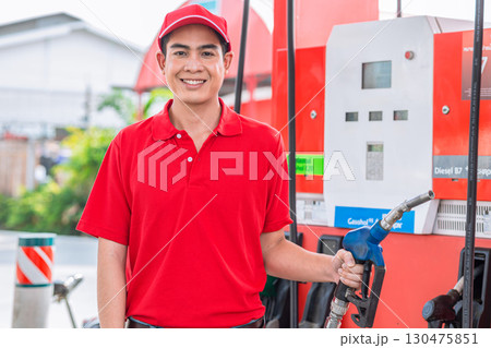 Happy gas station staff worker hand holding fuel nozzle for refill car fuel, Petroleum business 130475851