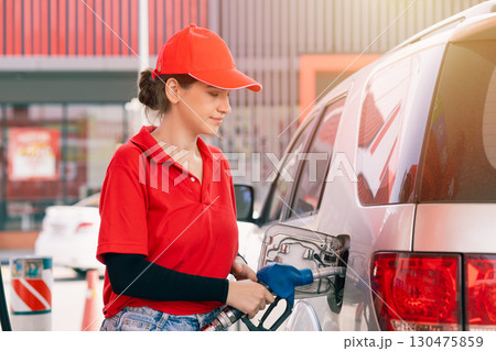Happy gas station staff worker latin women handle fuel nozzle for refill car fuel Happy gas station staff worker latin women handle fuel nozzle for refill car fuel 130475859