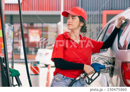 Happy gas station staff worker latin women handle fuel nozzle for refill car fuel Happy gas station staff worker latin women handle fuel nozzle for refill car fuel 130475860