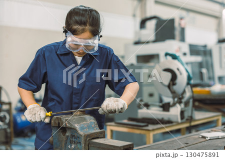 young teen technician Industry engineer student iron filing metal part in university workshop young teen technician Industry engineer student iron filing metal part in university workshop 130475891