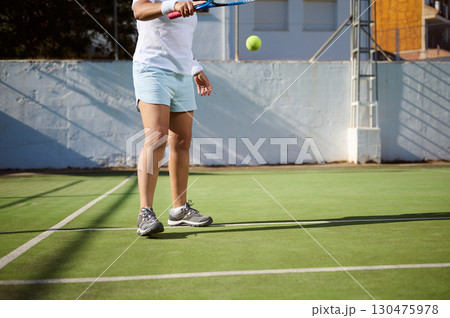 Player Practicing Tennis Skills on a Green Court in Action 130475978