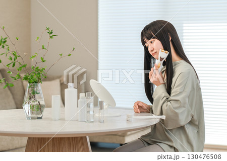 美顔器を使ってホームエステ・リフトアップ・マッサージする笑顔のアジア人女性（悩み,悩む,困る） 130476508