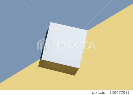 White cube, podium or box with shadow on diagonally divided yellow and blue background. 130477051