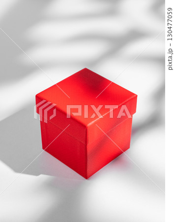Red box on a white background with soft shadows. Concept of a gift for a holiday Red box on a white background with soft shadows. Concept of a gift for a holiday 130477059