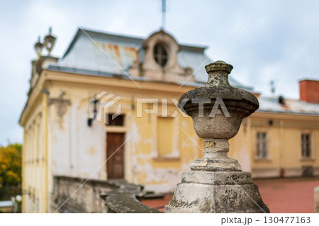 Historic building with ornate stone details under overcast sky in a serene landscape 130477163