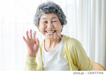 手を振るシニカメラ目線で両手を振る笑顔の高齢の女性ア女性 130477348