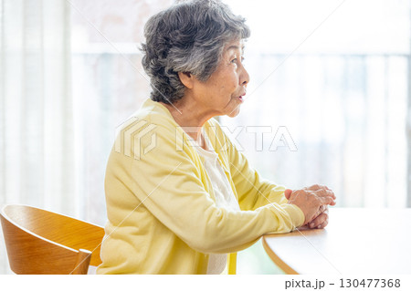 テーブルに椅子に座るシニア女性 130477368