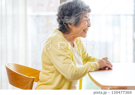 テーブルに椅子に座るシニア女性 130477369