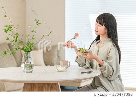 家でサラダを食べるダイエット中の若いアジア人女性 家でサラダを食べるダイエット中の若いアジア人女性 130477389