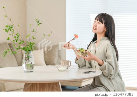 家でサラダを食べるダイエット中の若いアジア人女性 130477393