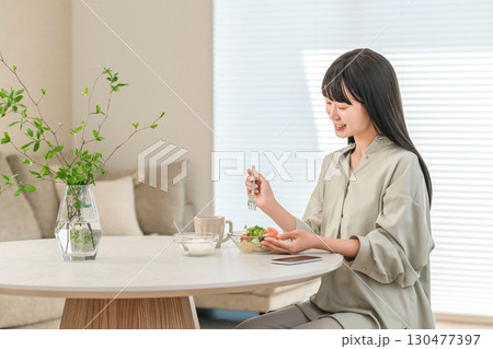 家でサラダを食べるダイエット中の若いアジア人女性 家でサラダを食べるダイエット中の若いアジア人女性 130477397